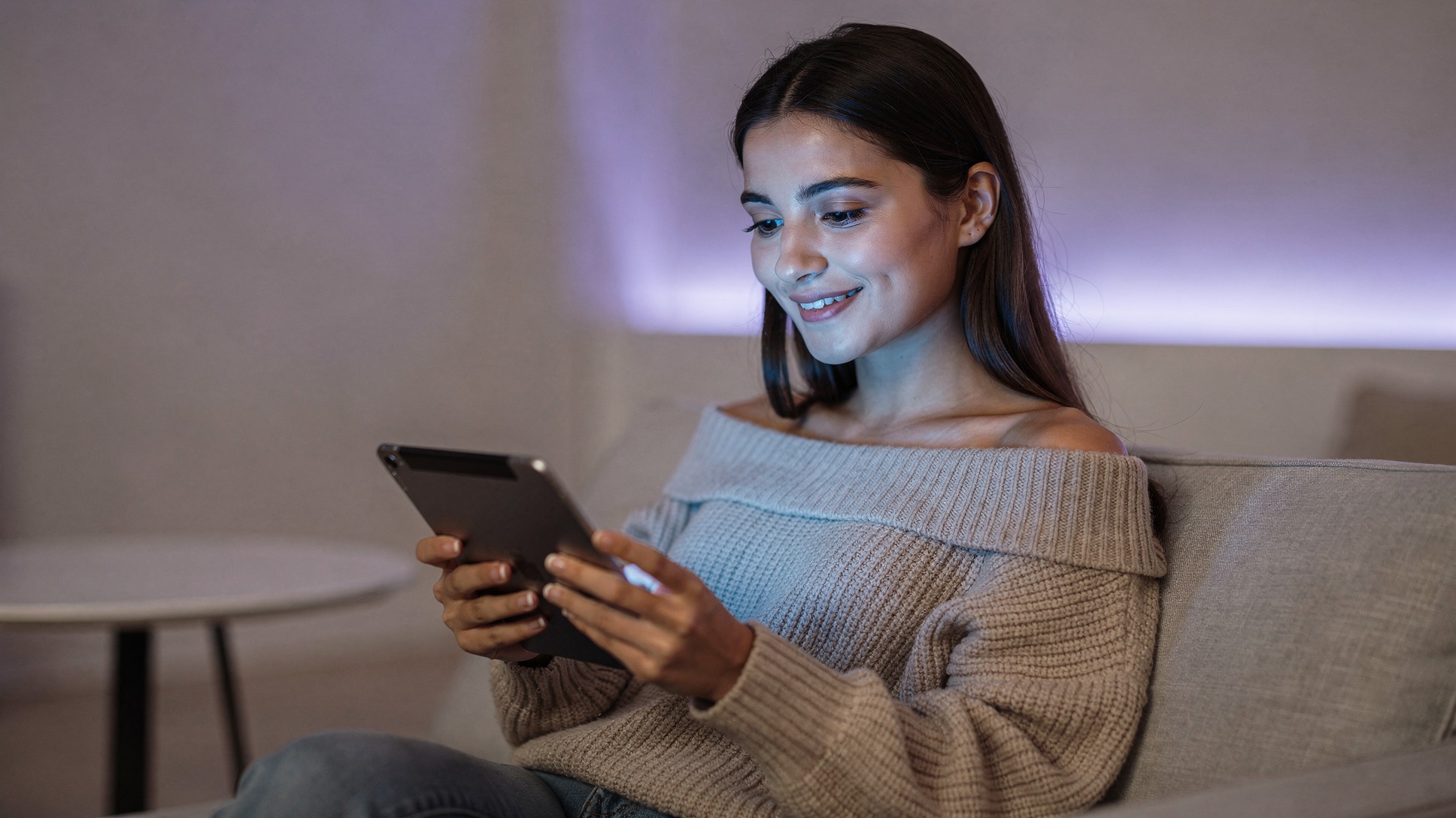 Woman comfortably browsing tablet with satisfied expression